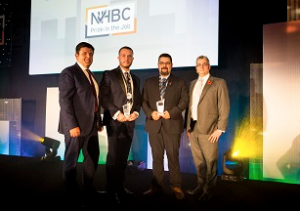 Four men on stage after receiving the award