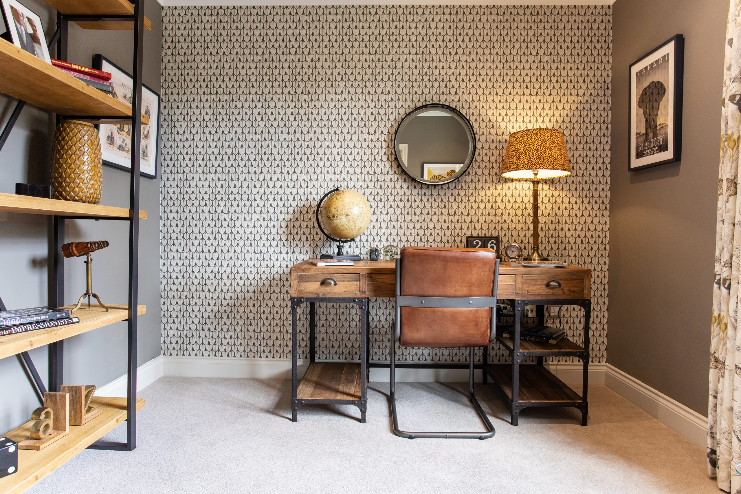 A desk with a lamp on in a study