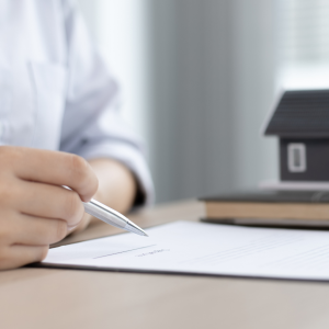 A hand signing a name on a mortgage in principle